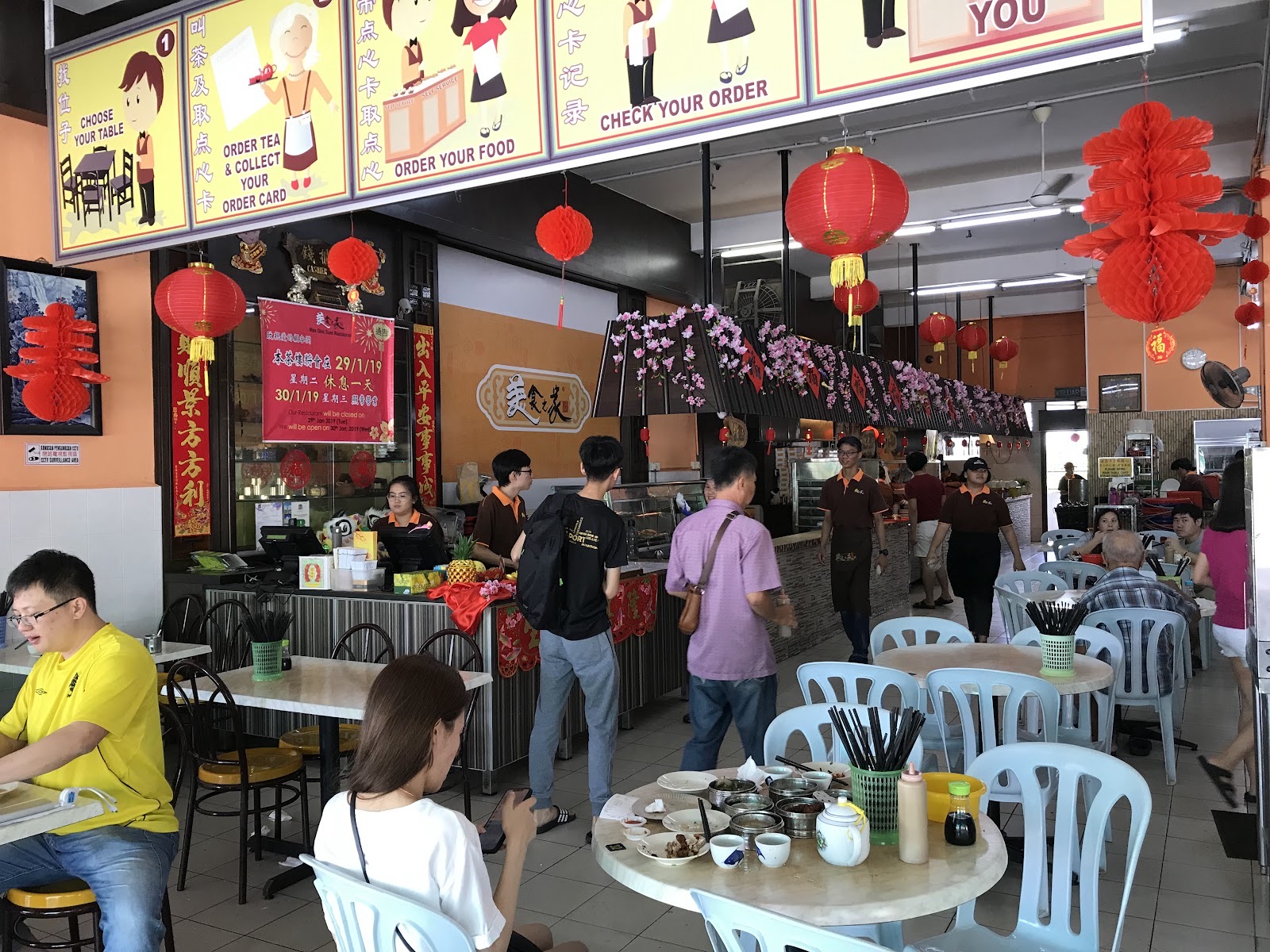 Maxim dining hall busy with families during a weekend tea hour, red lanterns hanging overhead
